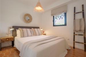 a bedroom with a white bed and a window at Villa Tosalet Pomelo in Jávea