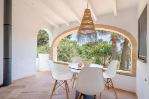 a dining room with a table and chairs and a window at Villa Tosalet Pomelo in Jávea