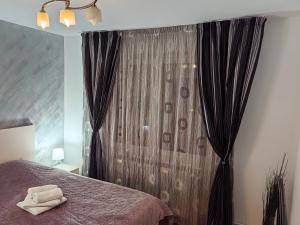 a bedroom with a bed and a window with curtains at Apartament Vultur - 3 rooms, 2 bathrooms in Târgu-Mureş