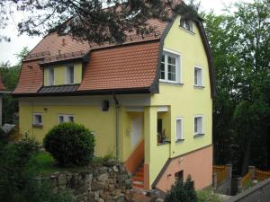 a yellow house with a red roof at Vila Anton in Karlovy Vary