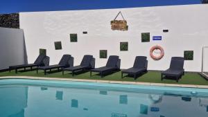 a group of chairs next to a swimming pool at Casa Vereda Ponta Delgada, S Miguel in Ponta Delgada