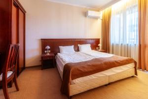 a hotel room with a large bed and a window at Downtown Bansko Resort in Bansko