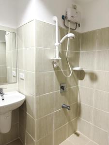 un baño con ducha y lavabo en The Embassy Pods, en Manila 5 fotos más