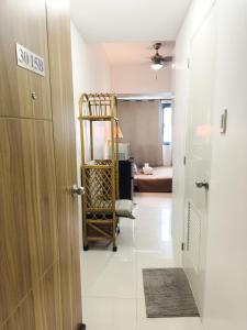 Un pasillo con una puerta y una habitación con una cama. en The Embassy Pods, en Manila