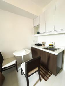 cocina con fregadero, mesa y sillas en The Embassy Pods, en Manila