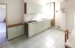 a kitchen with white cabinets and a sink at Lovely Apartment In Rosolina Mare in Rosolina Mare