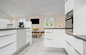 a kitchen with white cabinets and a dining room at Beautiful Home In Spøttrup With Wifi in Spottrup