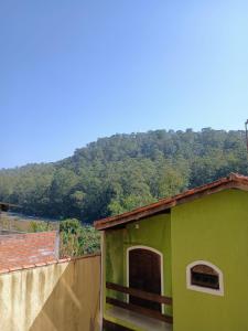 a green house with a mountain in the background at Sergio&rosa Animalia park CT Sao Paulo Termas da mata casa 360 in Cotia