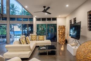 ein Wohnzimmer mit Sofa und Fernseher in der Unterkunft Diamond by the sea - Direct beach access in Newell Beach