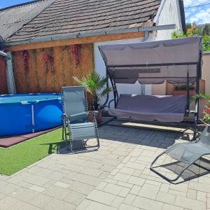 a patio with a bed and two chairs and a pool at Tünde lak in Siófok