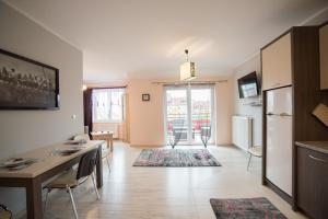 una cucina e un soggiorno con un tavolo e un frigorifero di Apartament Stella Polare a Giżycko