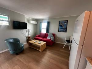 a living room with a red couch and a table at Playa Esmeralda suite 3 in Bradenton Beach