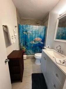 a bathroom with a fish shower curtain and a toilet at Playa Esmeralda suite 3 in Bradenton Beach +34 photos
