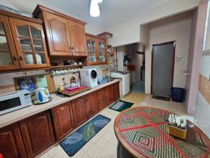 a kitchen with wooden cabinets and a table in it at Homestay LaNik Saujana Utama 2 in Sungai Buluh