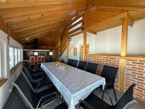 a dining room with a table and black chairs at Apartman Santro in Kupres