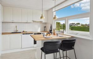 een keuken met witte kasten en een groot raam bij Bakkehuset in Hejls
