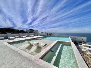 a swimming pool with a view of the ocean at Modern apartment with sea view in Mazatlán