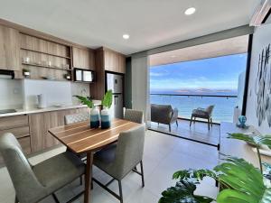 a kitchen and dining room with a view of the ocean at Modern apartment with sea view in Mazatlán