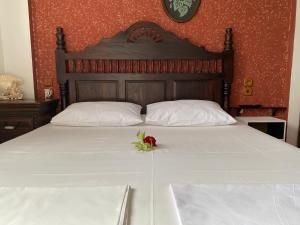 a white bed with a flower on top of it at Accommodation Villa Mallis in Chorto, Pelion in Chorto