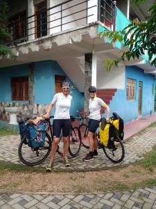 two people standing with their bikes in front of a building at Thomasha Homestay & Tuk Tuk Tour in Wellawaya