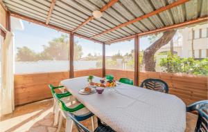 una sala da pranzo con un tavolo e sedie verdi di Stunning Home In Alcanar With Wifi ad Alcanar Altre 20 foto
