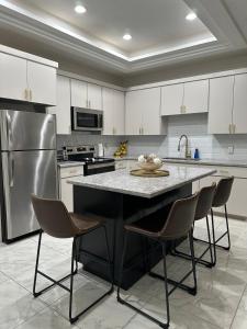 a kitchen with a large counter with chairs and a refrigerator at Carroll Estates 3 Bedroom Apartment Retreat in San Juan