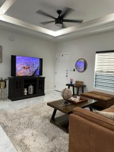 a living room with a flat screen tv and a couch at Carroll Estates 3 Bedroom Apartment Retreat in San Juan +25 photos