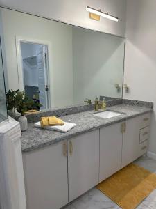 a bathroom with a sink and a large mirror at Carroll Estates 3 Bedroom Apartment Retreat in San Juan