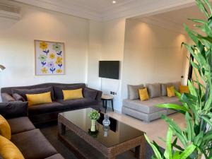 Appartement Vue Panoramique sur la siesta plage WELCOME STAY في المحمدية: غرفة معيشة مع أرائك وطاولة قهوة