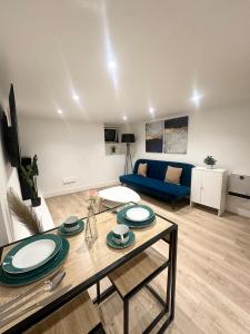 a living room with a table and a blue couch at Cosy 1 bedroom flat in London in London