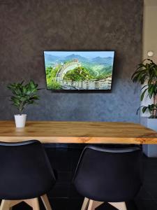 a table with two chairs and a tv on a wall at excelente calefacción, TV 55'' CON MUNDIAL 2026, Cochera, WIFI rapido, Colchón cómodo, Apartamento Gamán in San Luis +9 photos