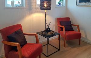 Una habitación con dos sillas y una mesa con una lámpara. en Stunning Home In Søgne With Wifi, en Søgne