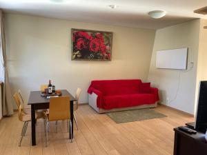 a living room with a red couch and a table at Maisonette Mountain View - Euphoria Resort in Borovets