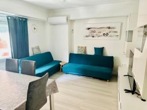 a living room with two blue couches and a table at Piso Lorena Playa 1min walk in Puerto de Sagunto