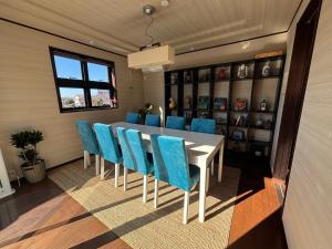 a dining room with a table and blue chairs at Cielito Hayama 最大10名 海まで10分 テラスBBQ 葉山の空と海と富士山に出会うヴィラ in Hayama