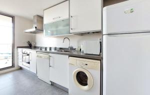 y cocina con lavadora, secadora y nevera. en Cozy Apartment In Moncofa, en Moncófar