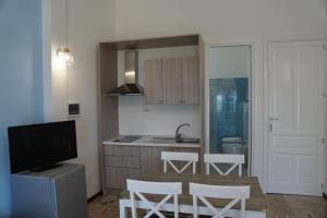 a kitchen with a table and chairs and a television at Case Vacanze Bedda Iole in Canneto