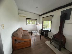 ein Wohnzimmer mit einer Couch und einem Klavier in der Unterkunft Rancho pura vida in San Carlos