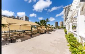 une passerelle avec bancs et parasols sur une plage dans l'établissement Waikiki Seaside Monarch Paradise Hotel Studio Near Waikiki - Mountain and City View - Full Kitchen, à Honolulu