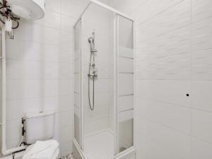 a white bathroom with a shower and a toilet at Spacious Studio - 2P - Levallois-Perret in Levallois-Perret +3 photos