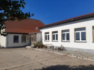 una casa bianca con una panchina davanti di Ferienhaus am grossen See in Fuerstenwerder a Fürstenwerder