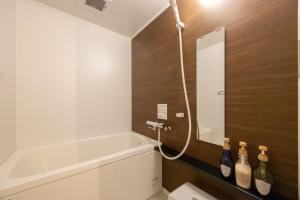 a bathroom with a tub and three bottles of wine at Fukuyama Royal Hotel - Vacation STAY 46784v in Fukuyama