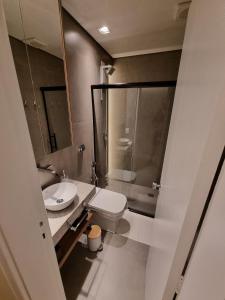 a bathroom with a toilet and a glass shower at Flat Asa Norte CLN 311 by CentoEdez in Brasilia +29 photos