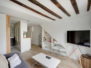 a living room with a couch and a tv at Charming studio near les Halles - Mobility lease in Paris