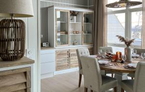 a dining room with a table and chairs and a kitchen at Gorgeous Home In Hurdal With Lake View in Hurdal