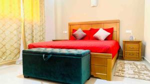 a bedroom with a red bed with a ottoman at Downtown apartment in Agadir