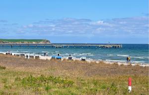 a beach with a pier and people in the water at Awesome Apartment In Hohen Wieschendorf in Hohen Wieschendorf