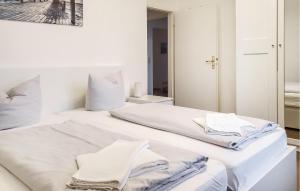 a white bedroom with two beds and a mirror at Awesome Apartment In Hohen Wieschendorf in Hohen Wieschendorf +6 photos