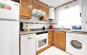 a kitchen with white appliances and wooden cabinets at Amazing Apartment In Oropesa Del Mar in Oropesa del Mar
