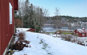グレンナにある1 Bedroom Stunning Home In Grännaの赤い家の横の雪に覆われた丘